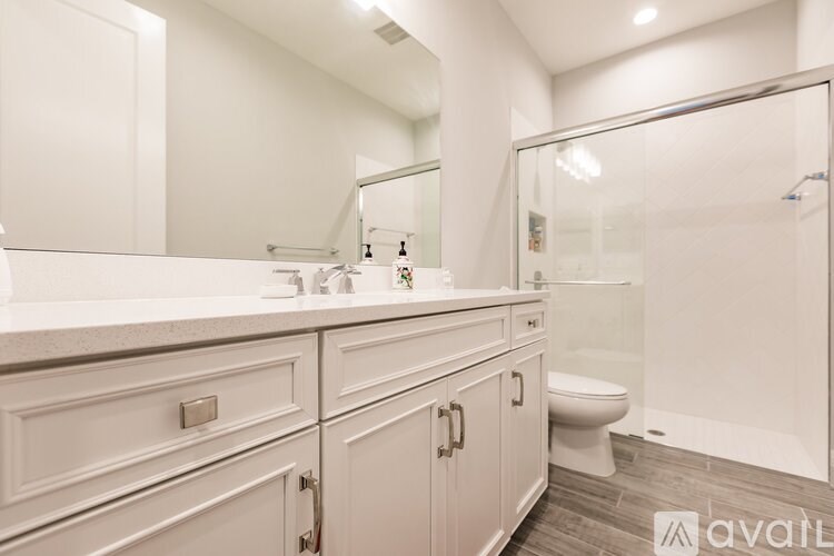 A bathroom with a white countertop and cabinets.
