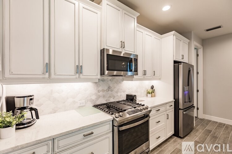 A kitchen with white cabinets and a black stove top.