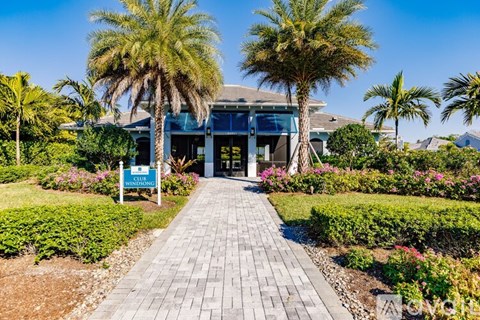 A pathway leads to a building with a sign that reads "Sunrise.".