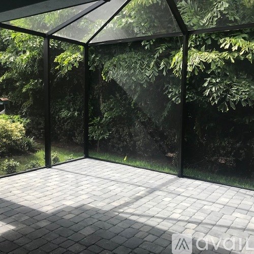 A glass enclosed patio with a tiled floor.