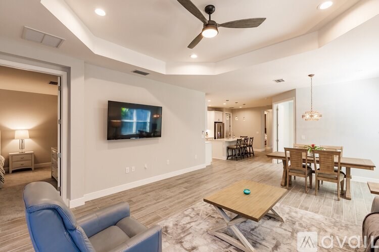 A living room with a television, a blue chair, and a wooden coffee table.