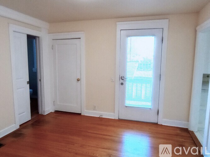 A room with white doors and a wooden floor.
