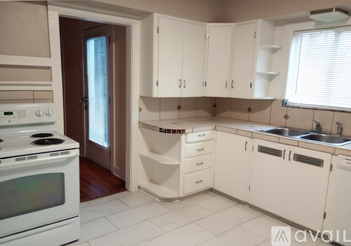 A kitchen with white appliances and cabinets.