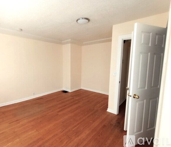 A room with a wooden floor and a white door.