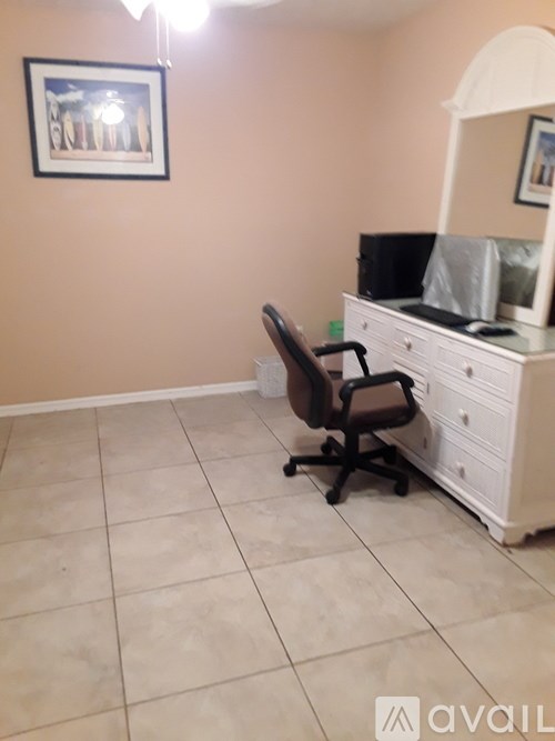 A room with a chair, a dresser, and a mirror.