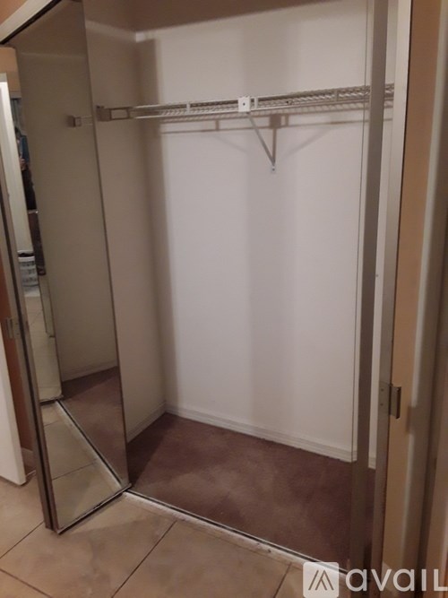 A walk-in closet with a white door and shelves.