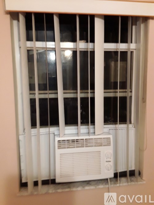A window with a white air conditioner unit installed inside it.