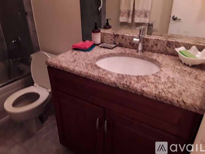 A bathroom with a granite countertop and a white sink.