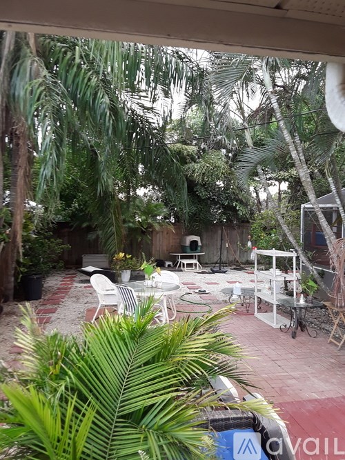 A patio with a table and chairs surrounded by trees.