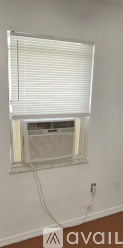 A window with white blinds and a white cord.