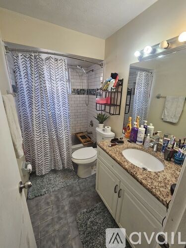 A bathroom with a toilet, sink, and shower.