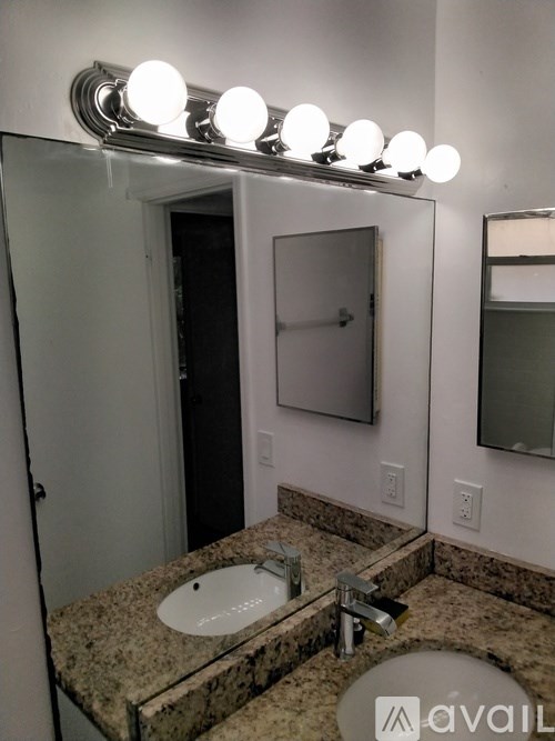 A bathroom with a granite counter top and a round sink.