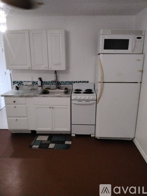 A kitchen with white appliances and cabinets.