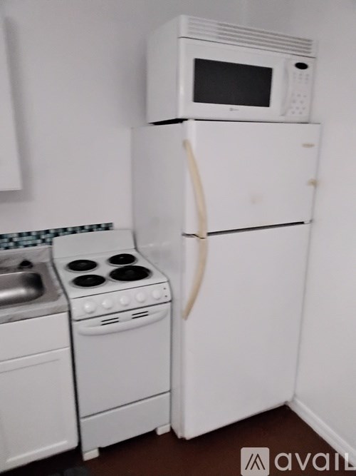 A white fridge with a microwave on top of it.