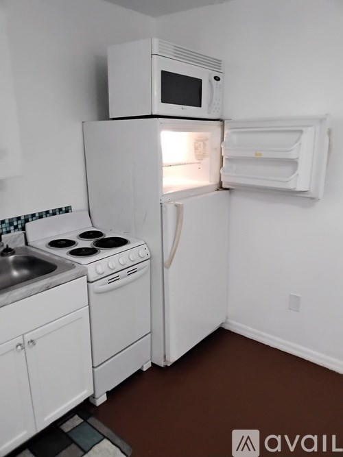 A small kitchen with a white fridge, microwave, and oven.