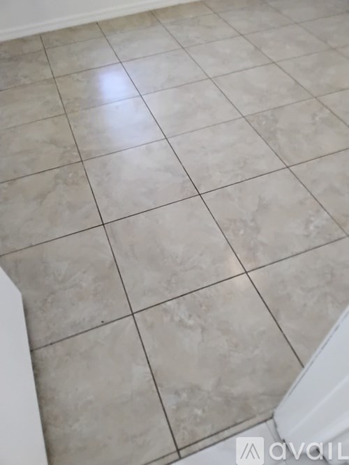 A room with beige tiled flooring and white walls.