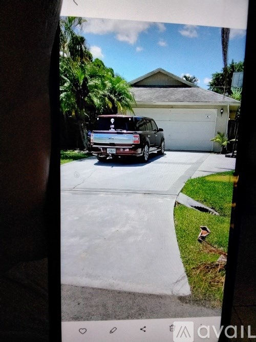A black car is parked in front of a house.