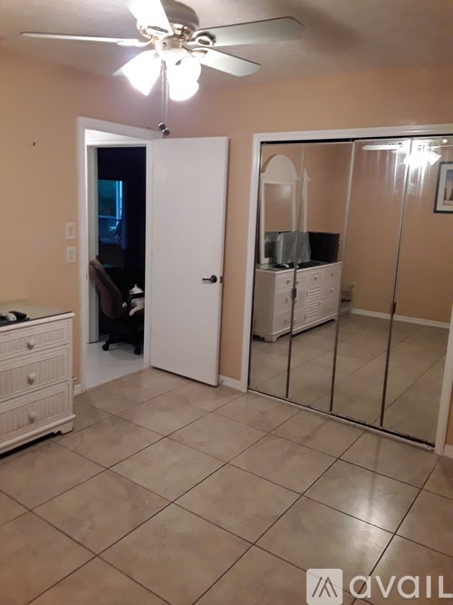 A room with a ceiling fan and a dresser.