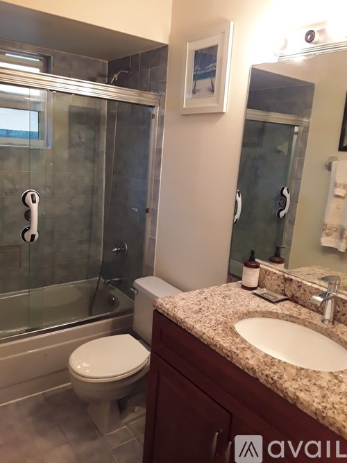 A bathroom with a toilet, sink, and shower.