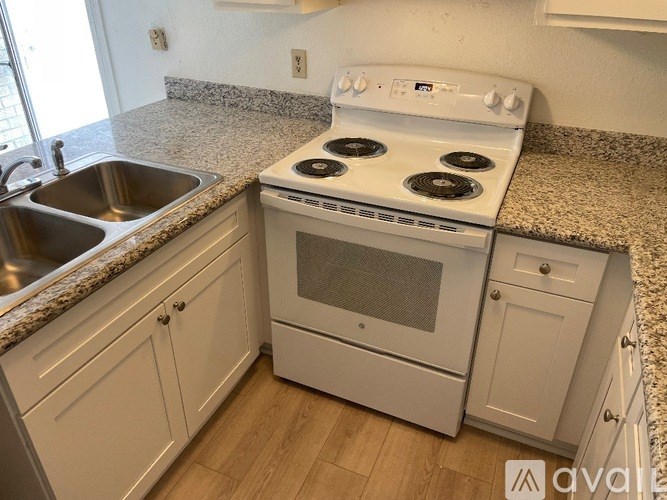 A white stove and oven in a kitchen with granite countertops.