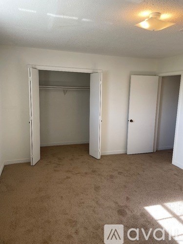 A room with a carpeted floor and a white door.