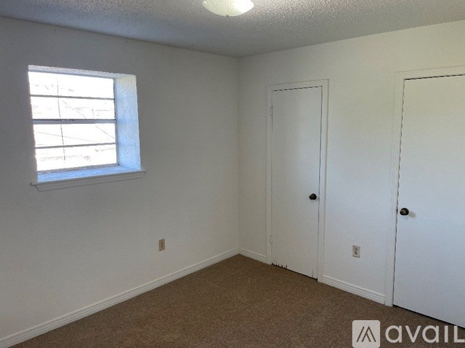 A room with a window and two doors.