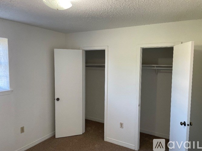 A room with two white doors and a window.