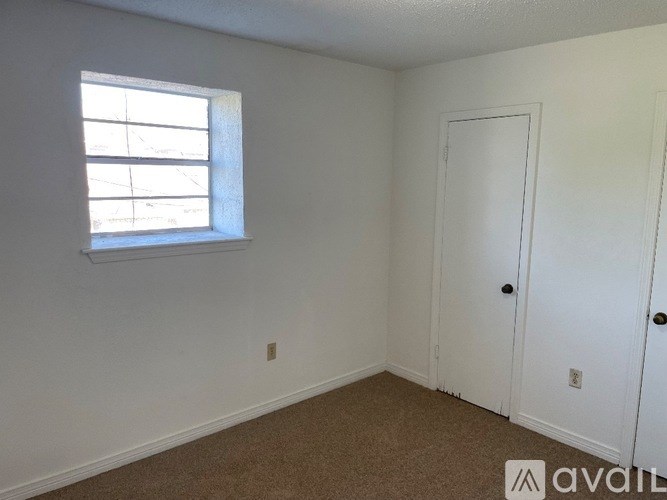 A room with a window and two doors is available for rent.