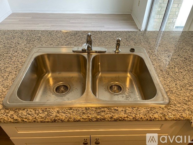 A double sink in a granite countertop.
