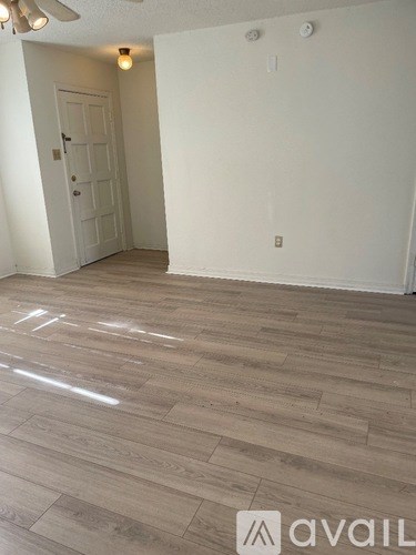 A room with wooden flooring and a ceiling fan.