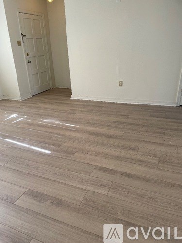 A room with wooden flooring and a white door.