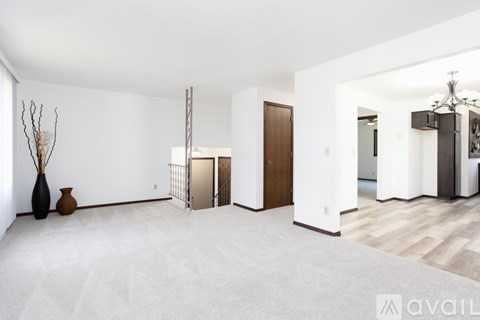A spacious living room with a white carpet and a wooden floor.