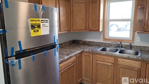 A stainless steel refrigerator with a label on it in a kitchen.