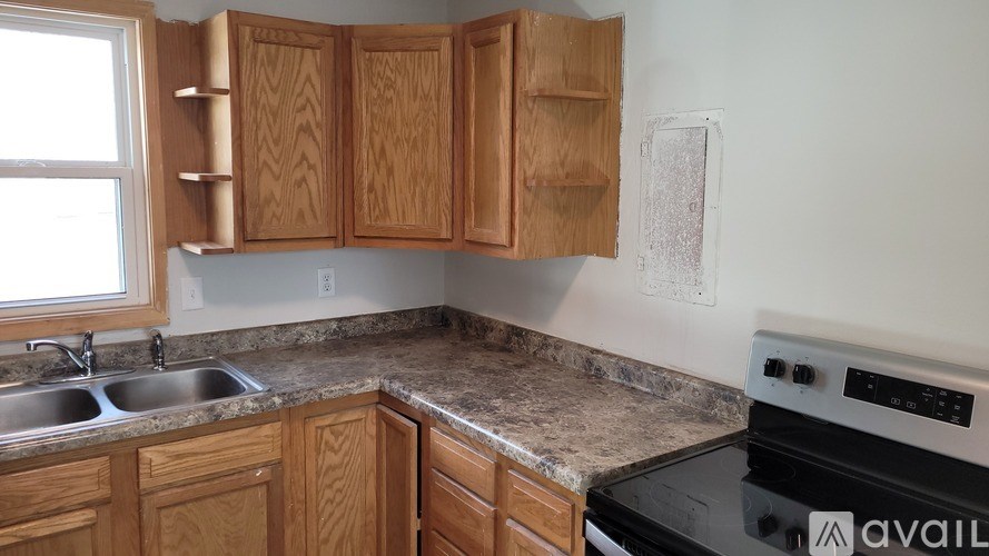 A kitchen with wooden cabinets and a black oven.