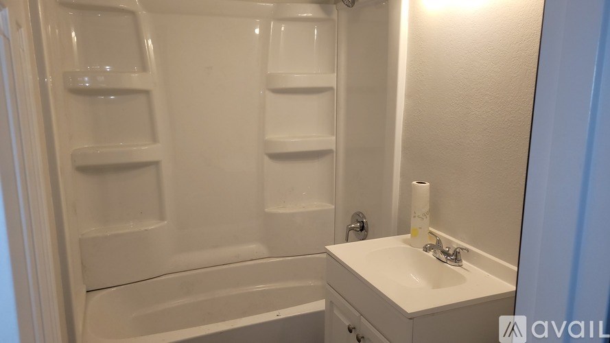 A white bathroom with a sink and a bathtub.