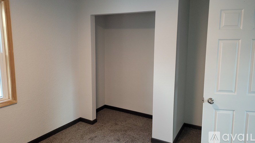 A room with a carpeted floor and a white door.