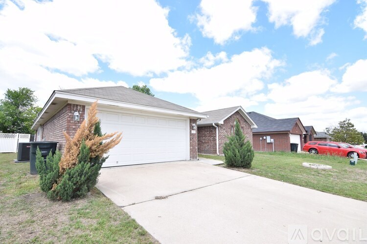 A house with a red car parked in the driveway.