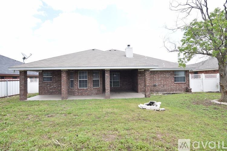 A house with a white fence and a tree in front.