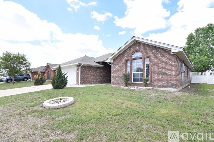 A house with a brick exterior and a white fence is for sale.