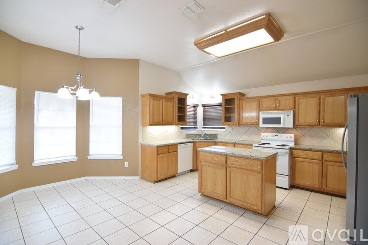 A kitchen with wooden cabinets and white appliances.