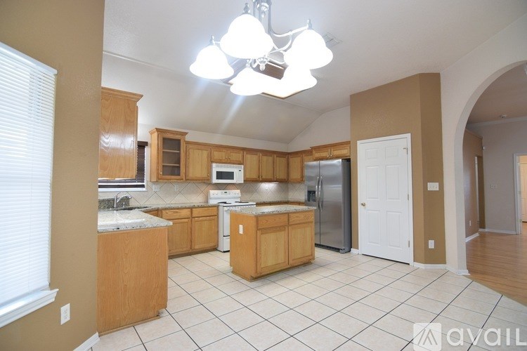 A kitchen with wooden cabinets and a white fridge.