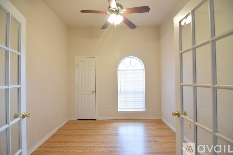 A room with a ceiling fan and a window.