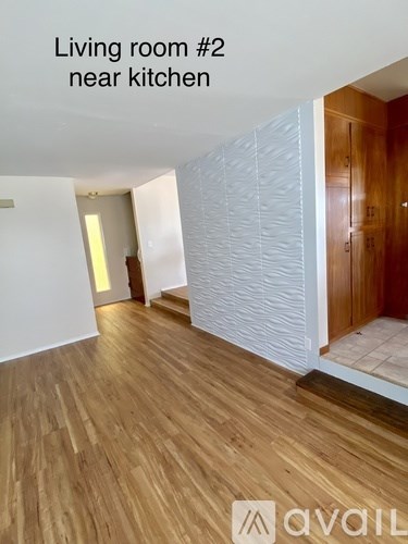A living room with wooden floors and a white wall.