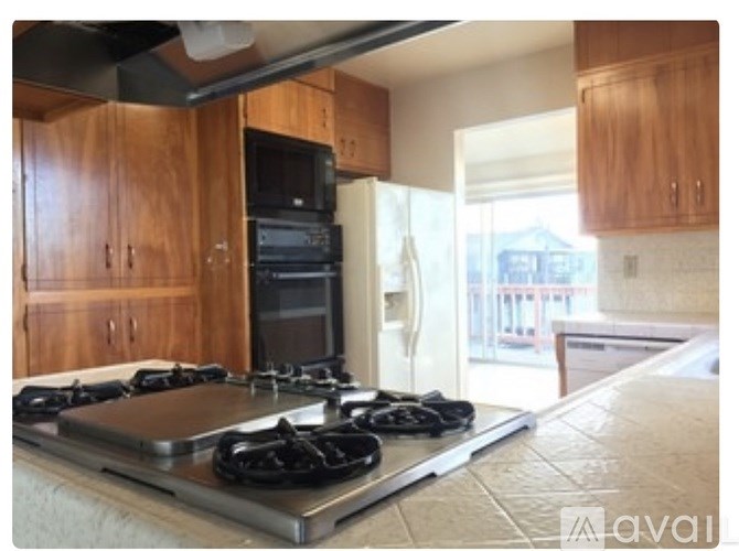 A kitchen with a stove top oven and a refrigerator.