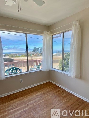 A room with a view of the ocean through the windows.