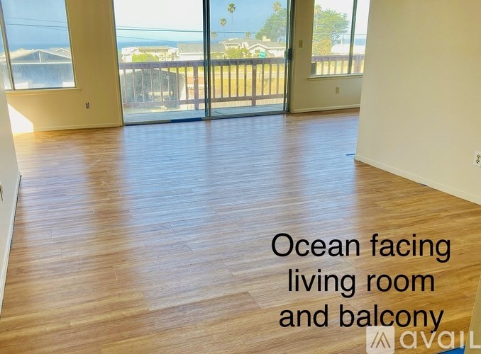 A living room and balcony with a view of the ocean.