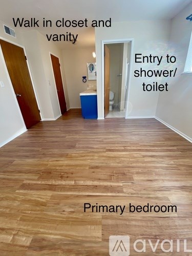 A room with wooden flooring and a blue vanity unit.