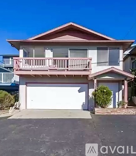 A two-story house with a balcony and a garage.