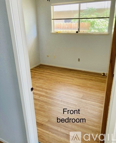 A room with wooden flooring and a window is labeled as the front bedroom.