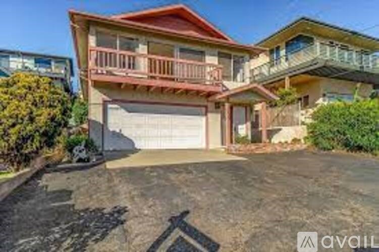 A two-story house with a red roof and a garage.